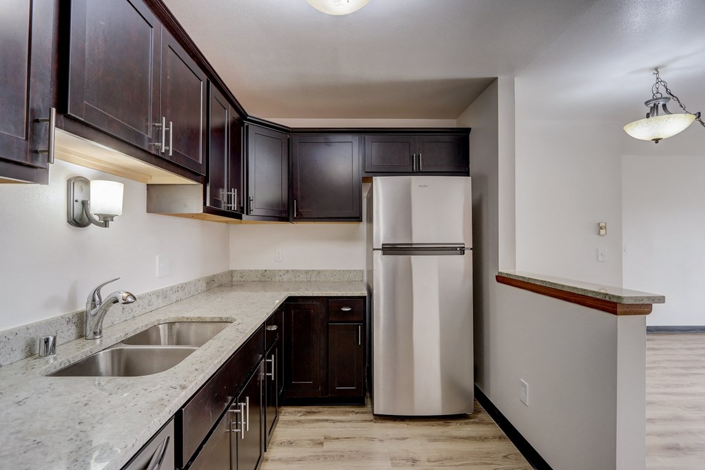 a kitchen with dark cabinets and a white refrigerator
