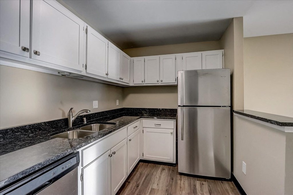 a kitchen with white cabinets and a stainless steel refrigerator