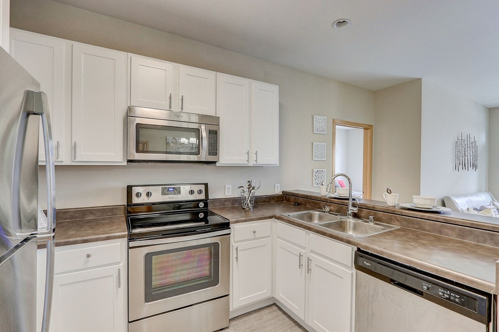 a kitchen with stainless steel appliances and white cabinets