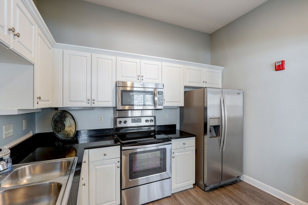 a kitchen with stainless steel appliances and white cabinets