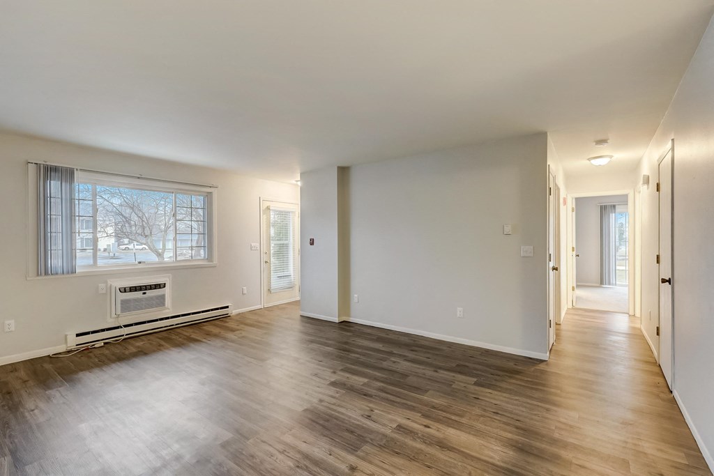 a bedroom with hardwood floors and white walls