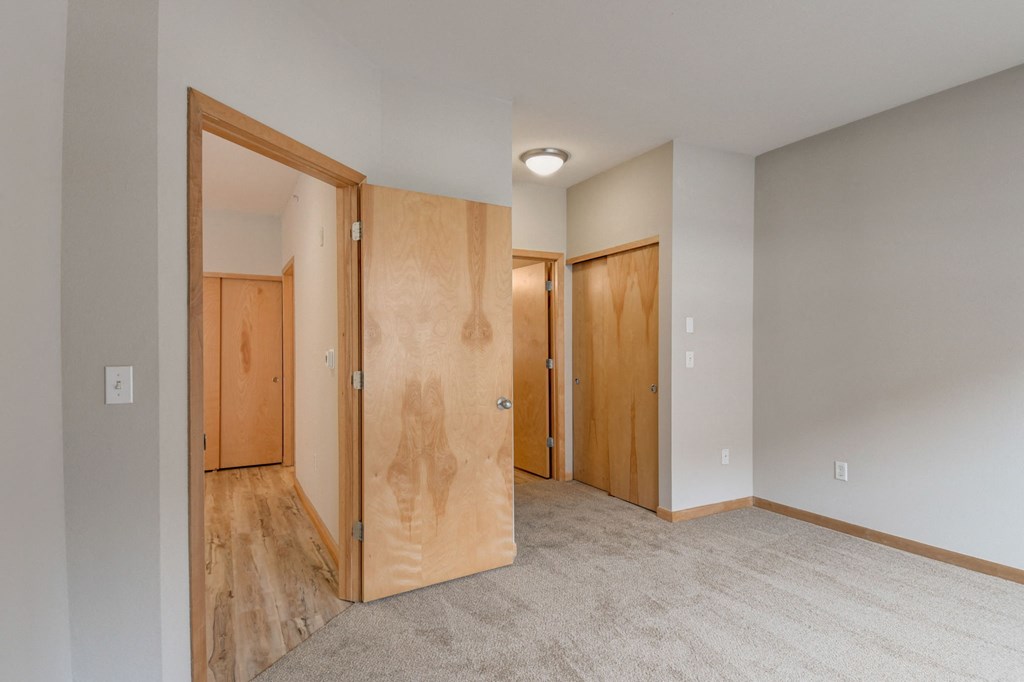 an empty room with wooden doors and a carpeted floor