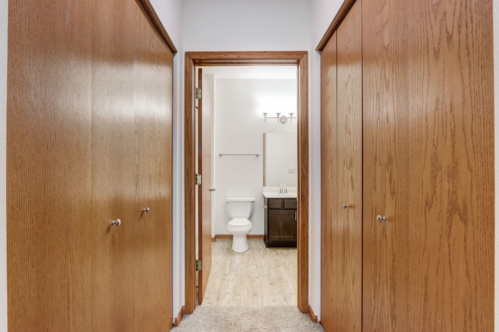 a bathroom with a toilet and wooden doors