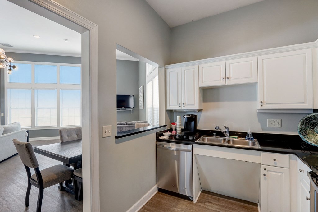 a kitchen with white cabinets and a sink and a window