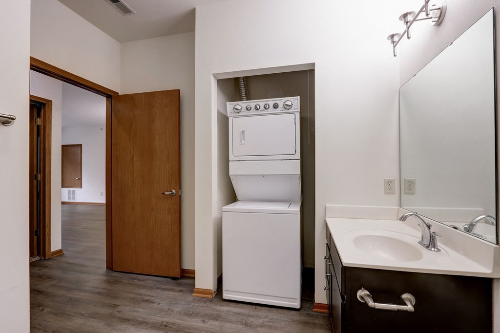 a bathroom with a washer and dryer and a sink and a laundry room