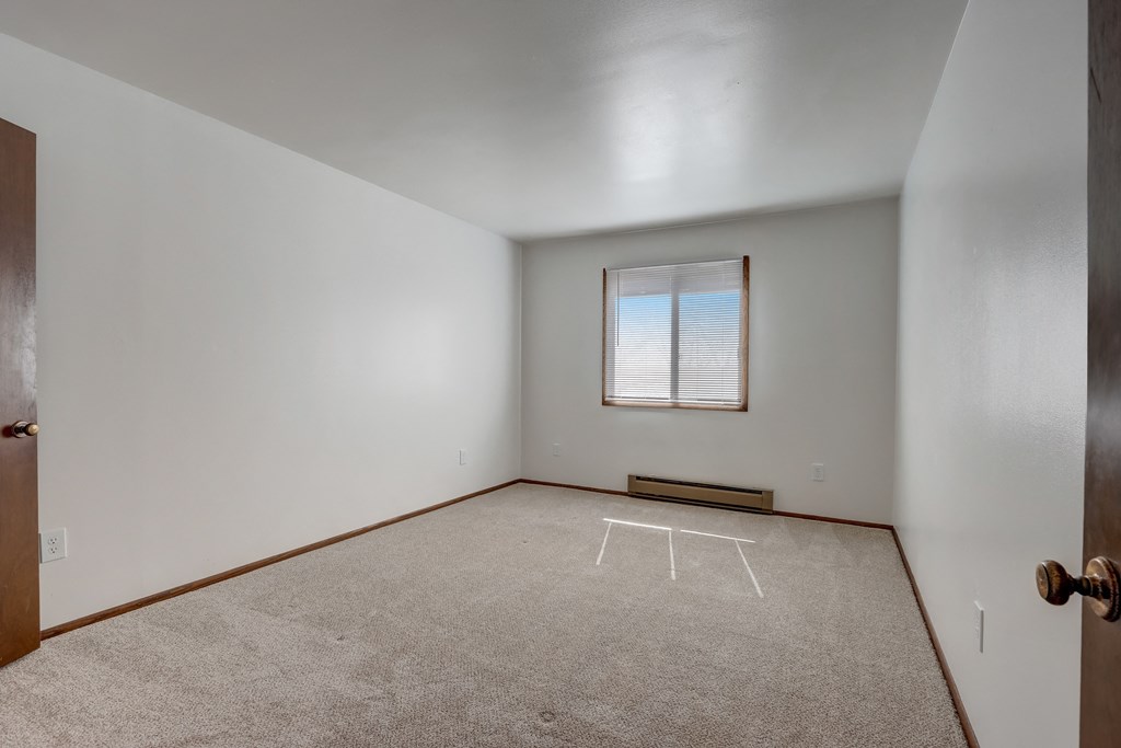 a bedroom with white walls and carpet