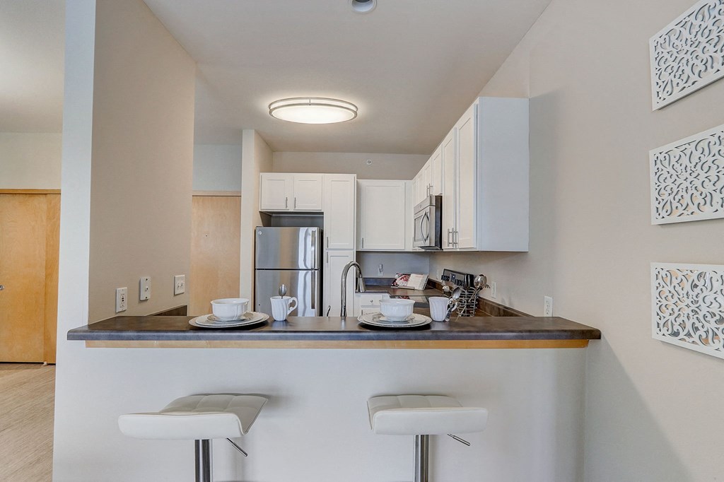 a kitchen with a bar and stools in a apartment
