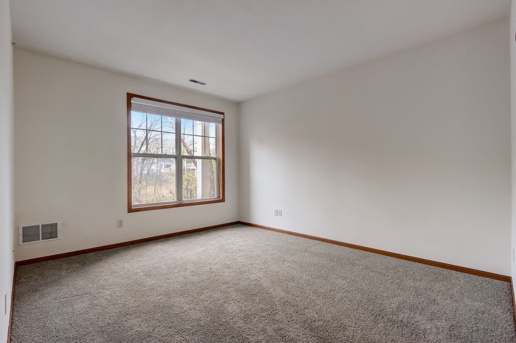 an empty room with carpet and a window