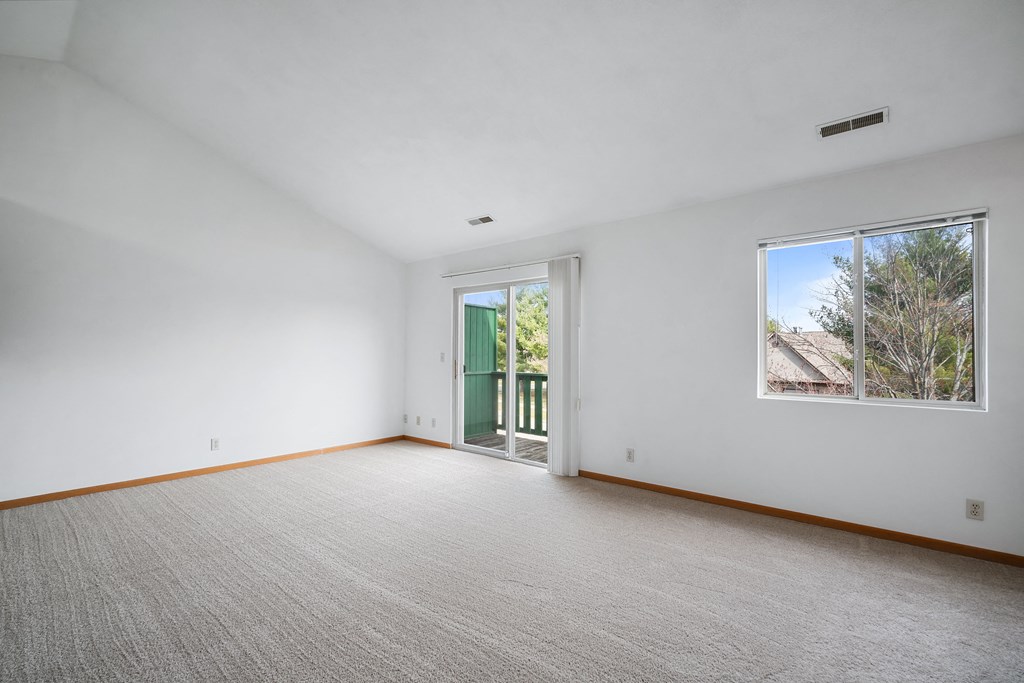 a living room with a large window and a door to a balcony