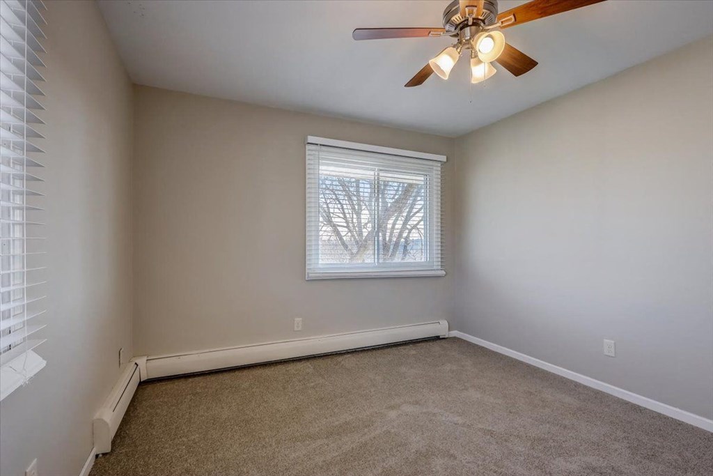 a bedroom with a ceiling fan and a window