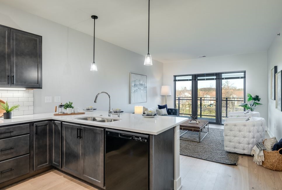 A modern kitchen with dark wood cabinets and a white countertop.