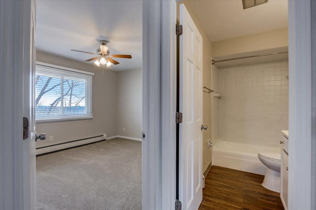 a bathroom with a ceiling fan and a window
