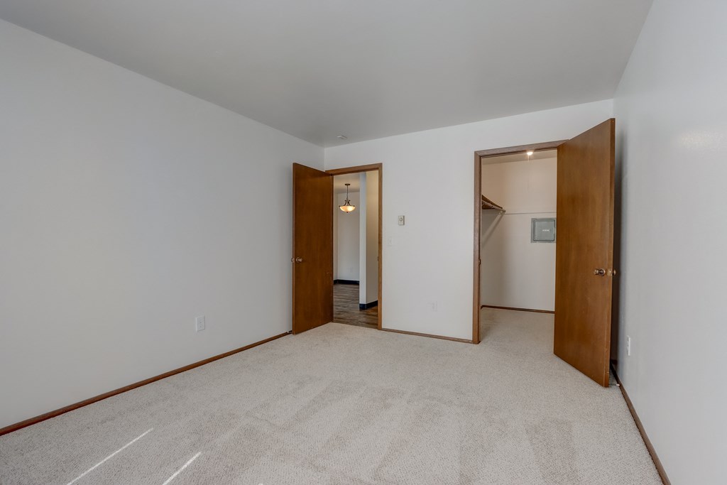a bedroom with white walls and a carpeted floor