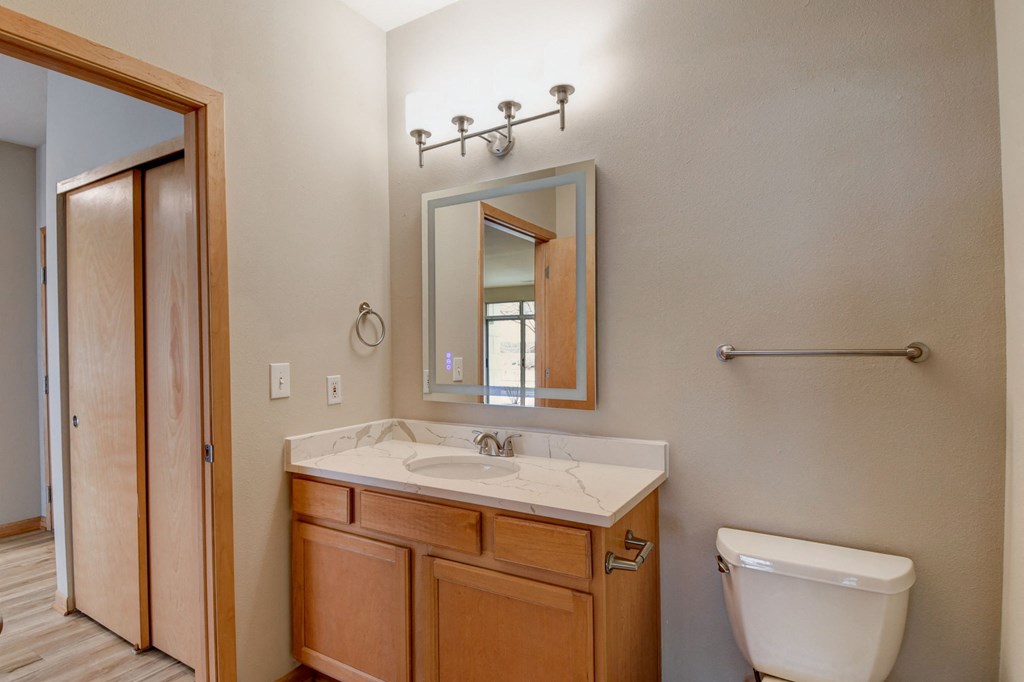 the master ensuite bathroom has a large mirror and a toilet