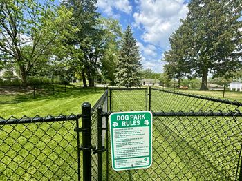 A sign on a fence that says Dog Park Rules.