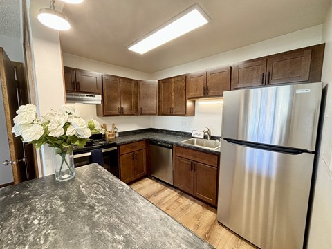 A kitchen with a granite countertop and stainless steel appliances.