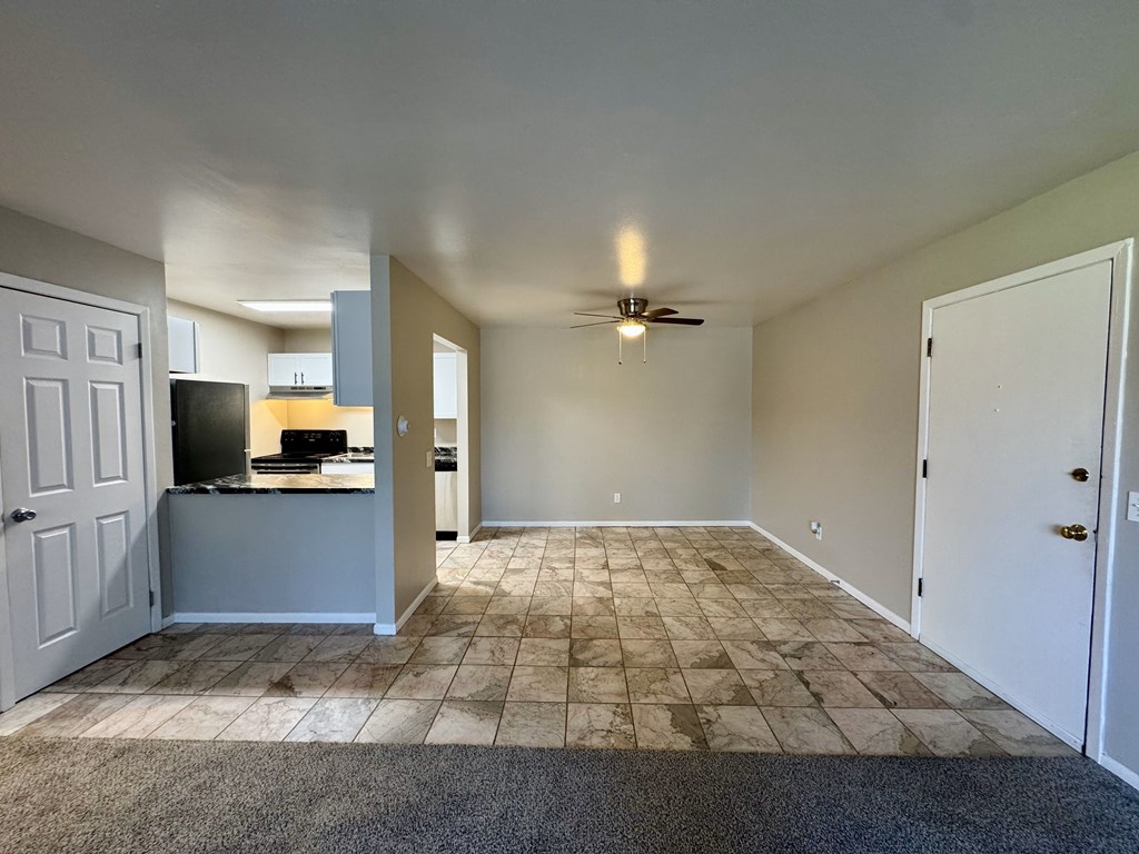 A room with a ceiling fan and tiled floor.