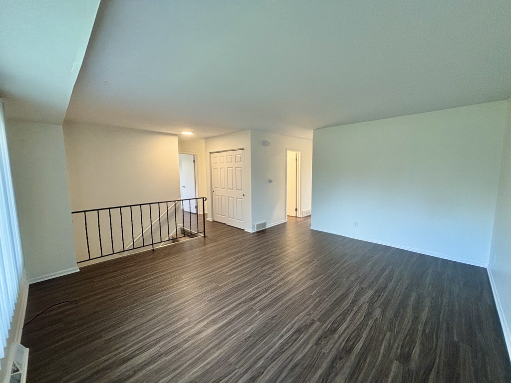 A room with wooden flooring and white walls.