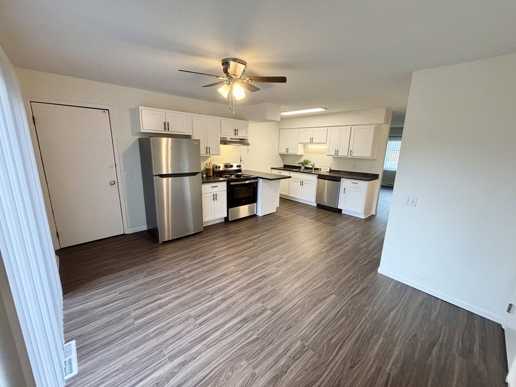A kitchen with a refrigerator, stove, and oven.