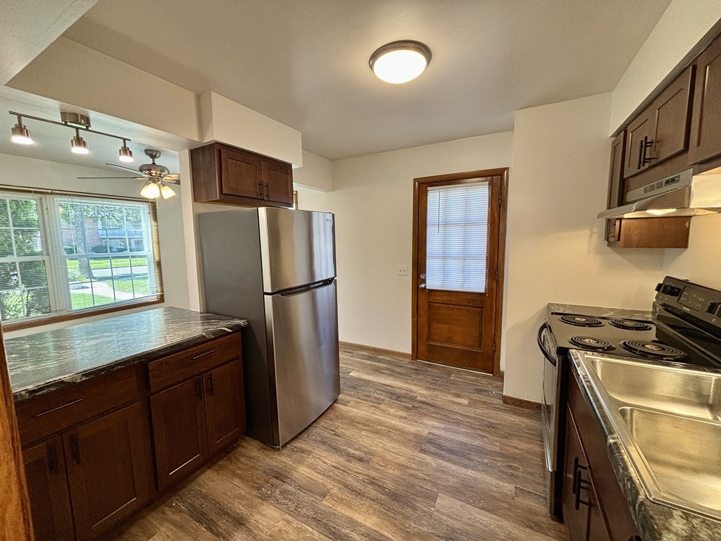 A kitchen with a refrigerator, stove, and sink.