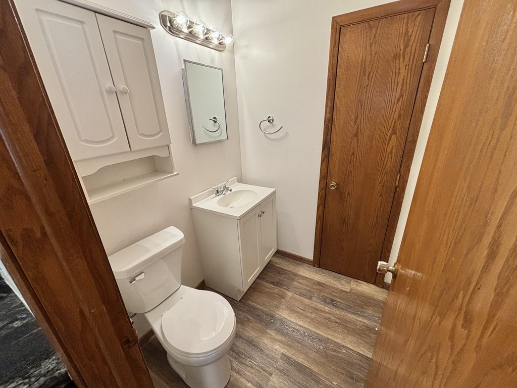 A white toilet and sink in a small bathroom.