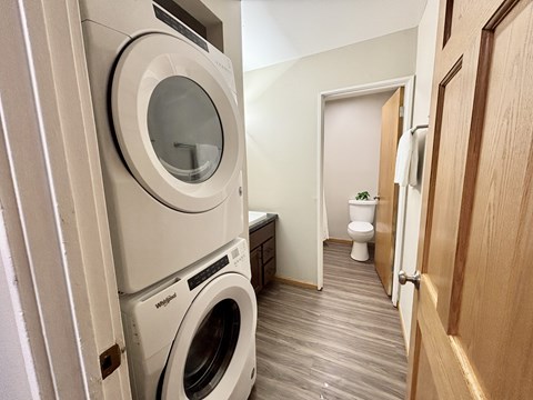 A laundry room with a washer and dryer stacked on top of each other.
