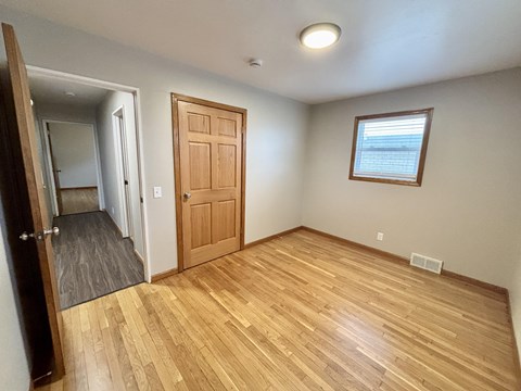 A room with a wooden floor and a door.