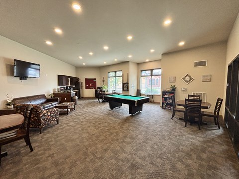 A spacious living room with a pool table and comfortable seating.