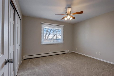 a bedroom with a ceiling fan and a window