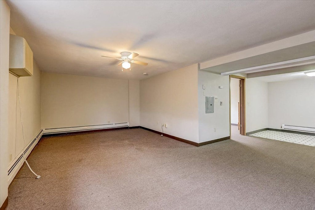 an empty living room with a ceiling fan
