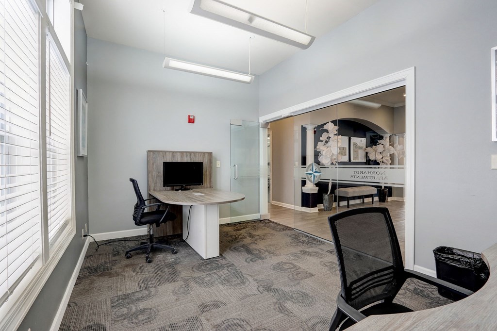 a conference room with a fireplace and a desk and chairs