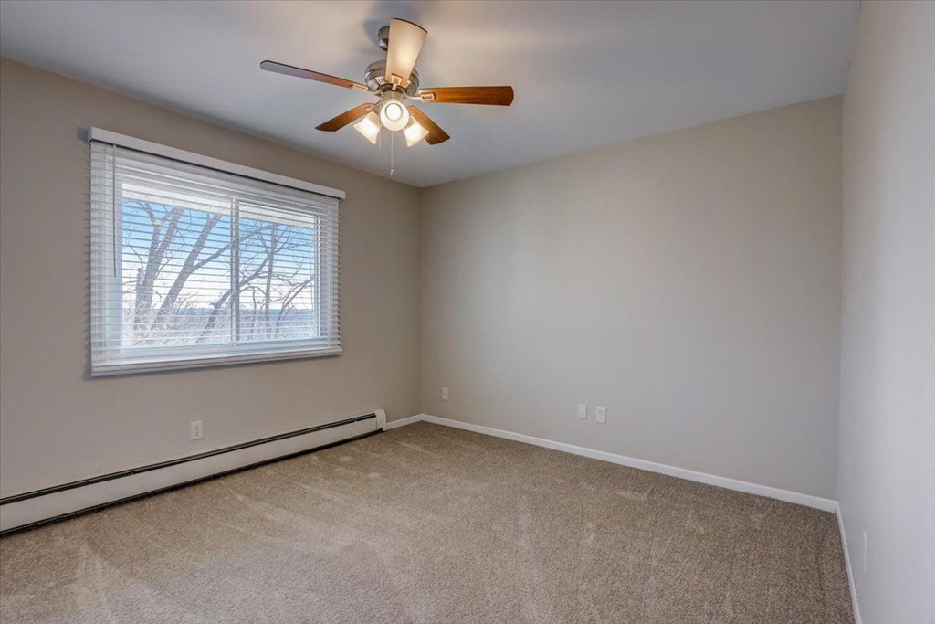 a bedroom with a ceiling fan and a window