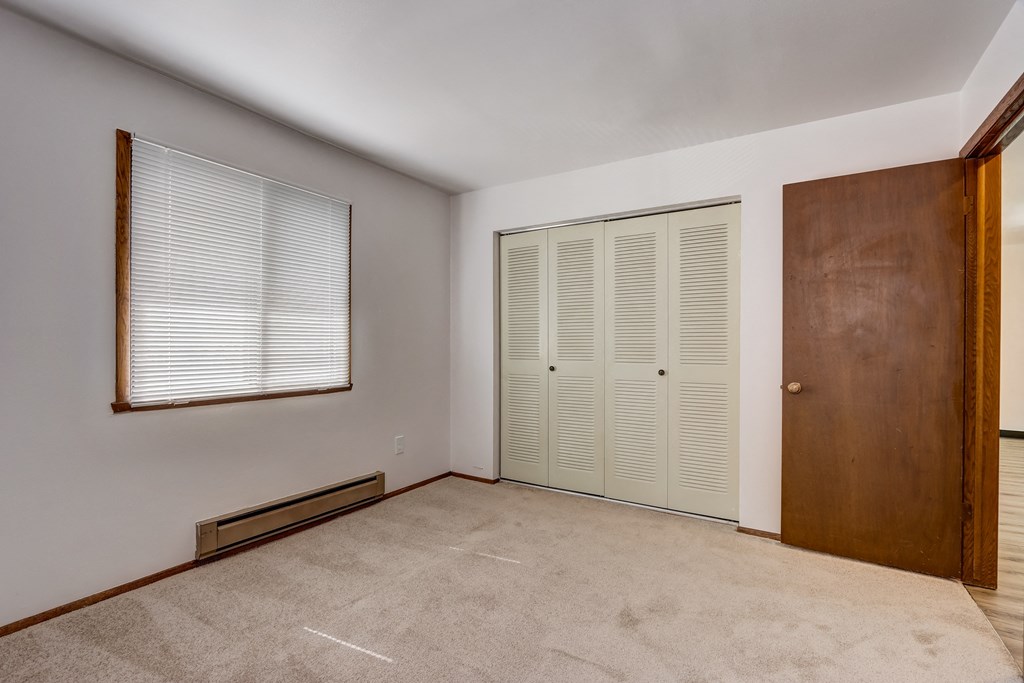 a bedroom with two closets and a window