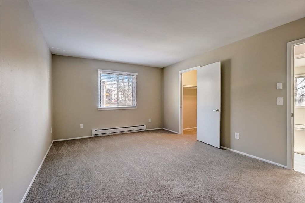 an empty living room with an open door and a window