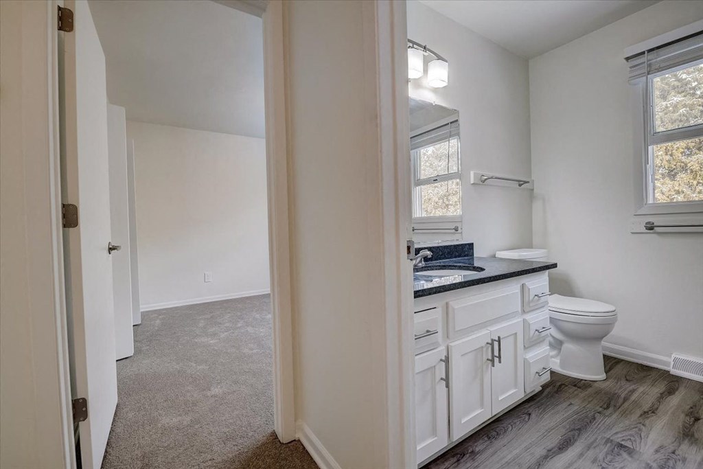 a white bathroom with a toilet and a sink