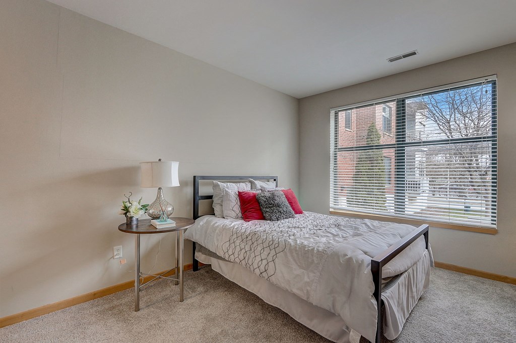 a bedroom with a bed and a large window