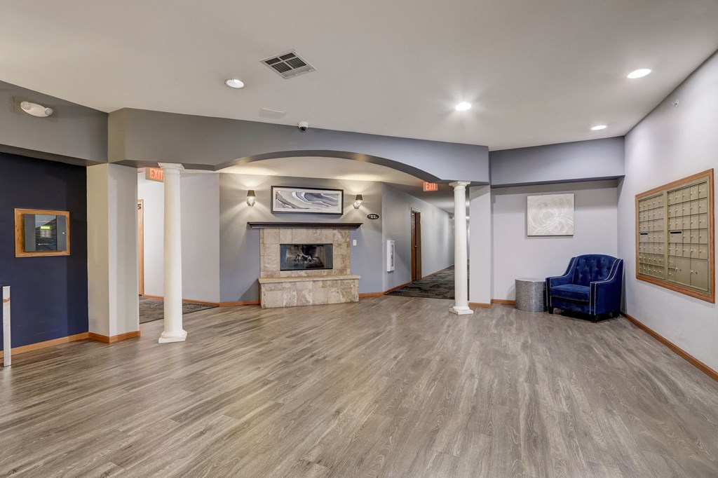 a spacious living room with a fireplace and a blue couch