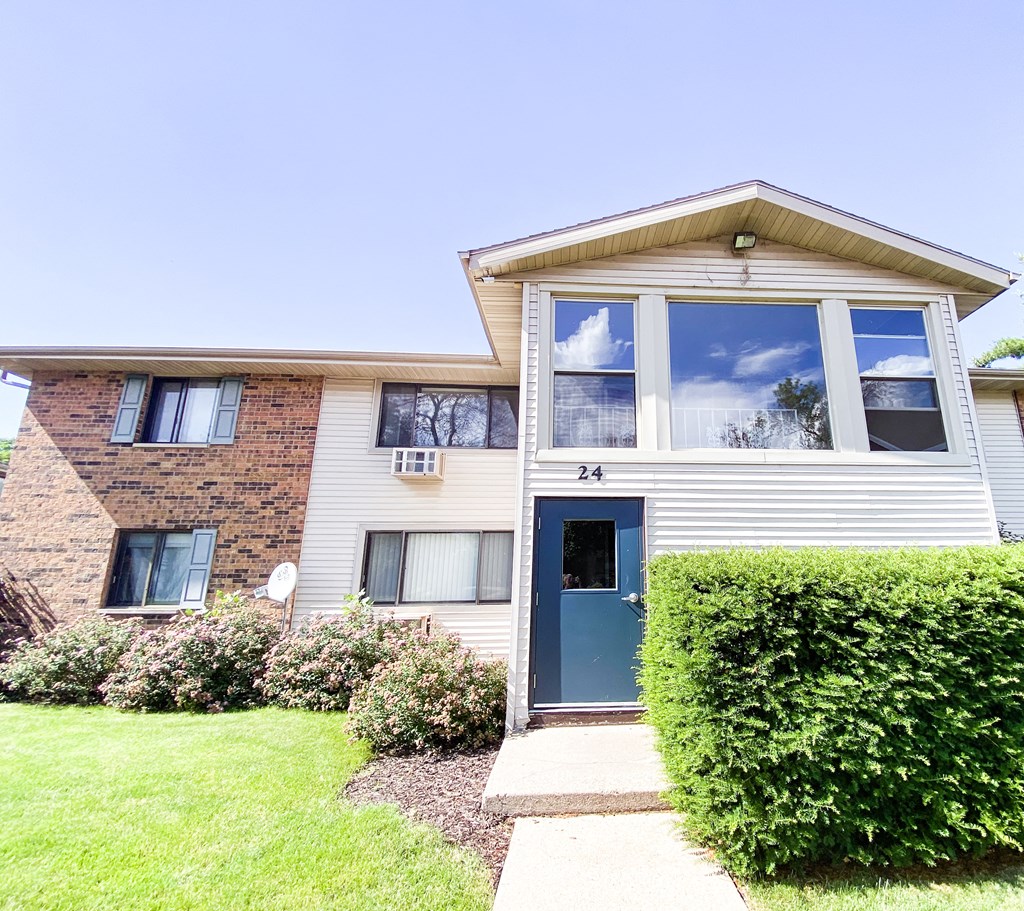 the front of a white house with a blue door