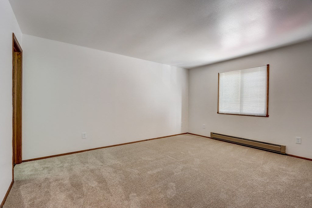 a bedroom with white walls and carpet