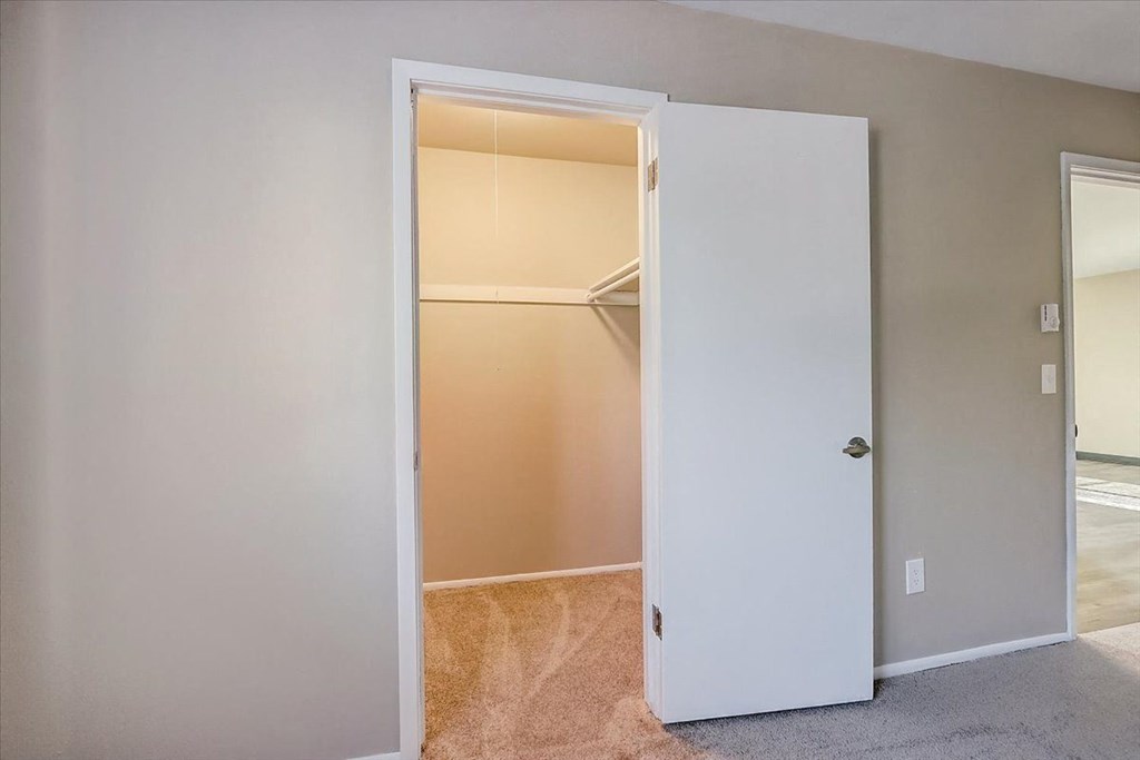 an empty closet in a room with a door open