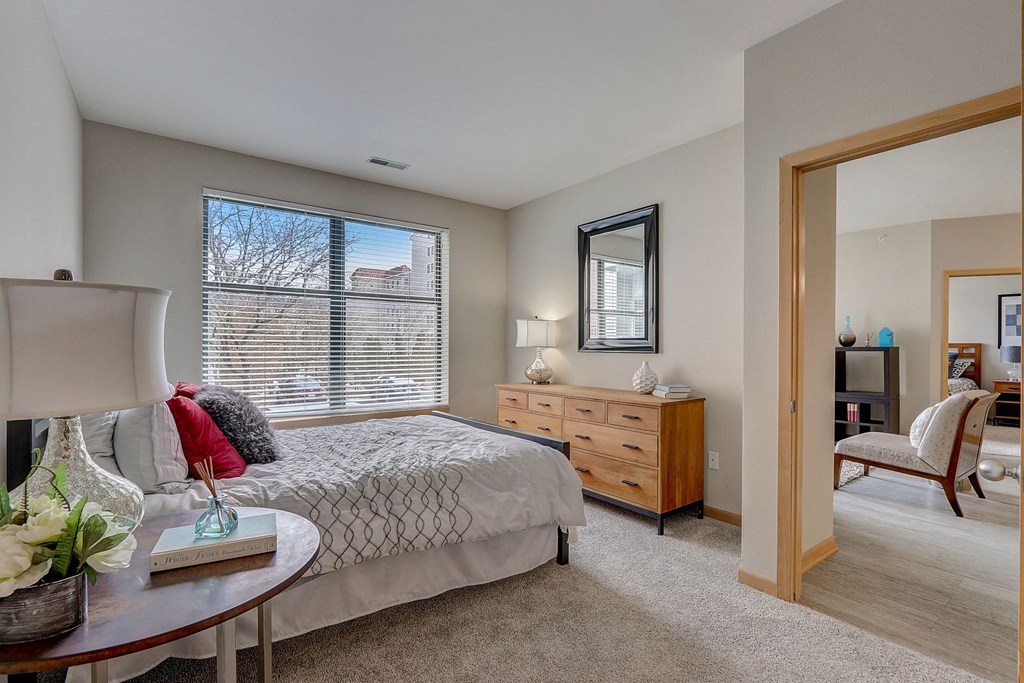 a bedroom with a bed and a desk and a mirror