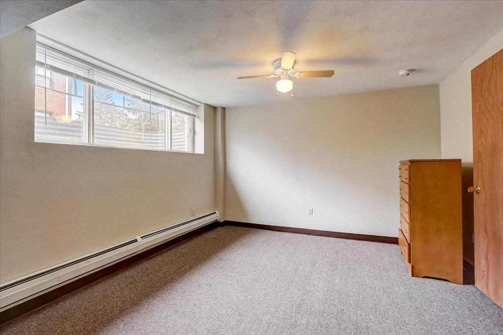 an empty bedroom with a ceiling fan and a closet
