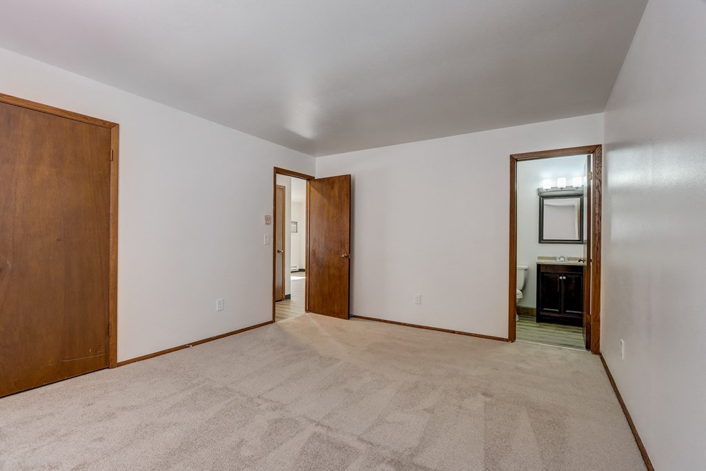 a bedroom with white walls and a carpeted floor