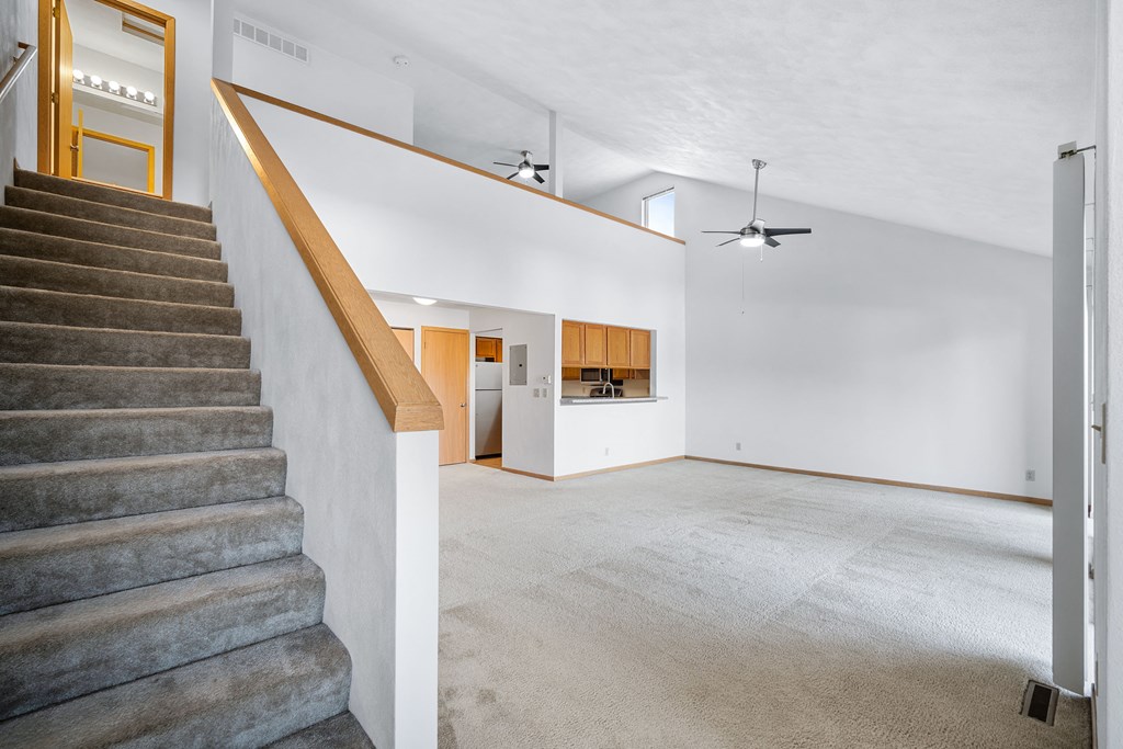 a living room with a staircase and a white wall