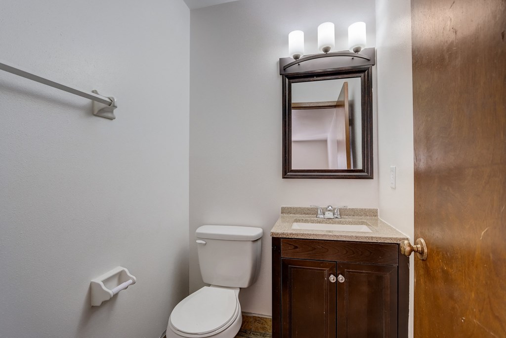 a bathroom with a toilet sink and mirror