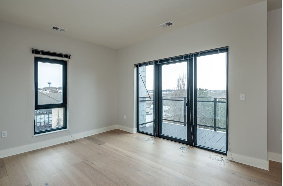 A room with a sliding glass door leading to a balcony.