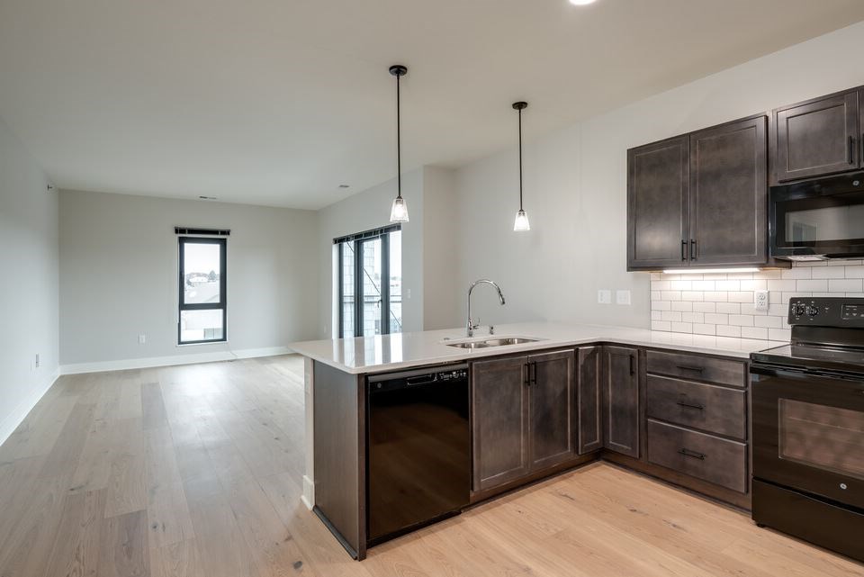 A kitchen with dark wood cabinets and a white countertop.