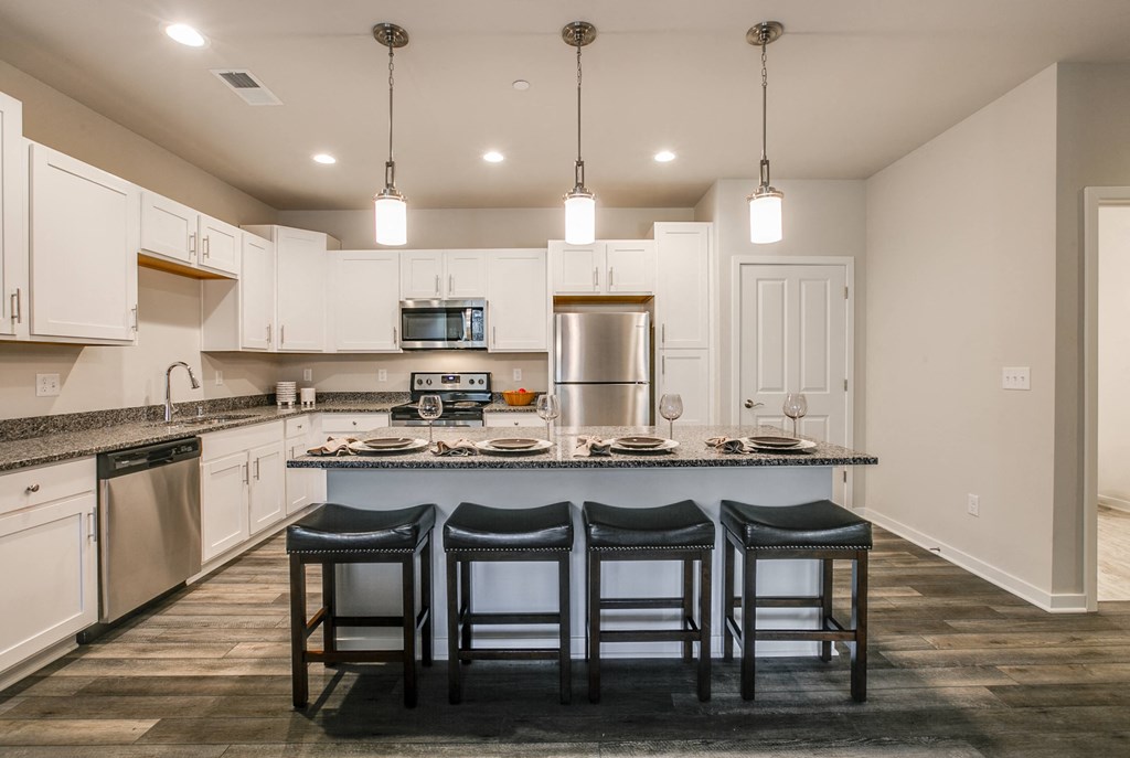 a kitchen with a large island with three stools