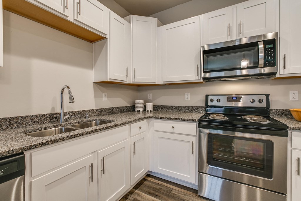 a kitchen with stainless steel appliances and white cabinets