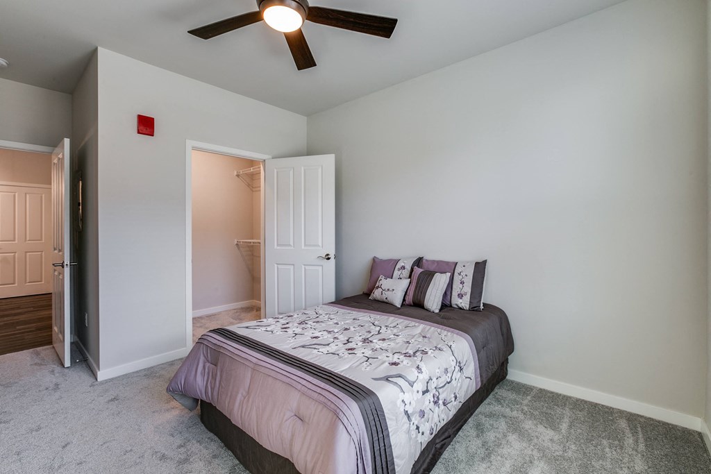 a bedroom with a bed and a ceiling fan